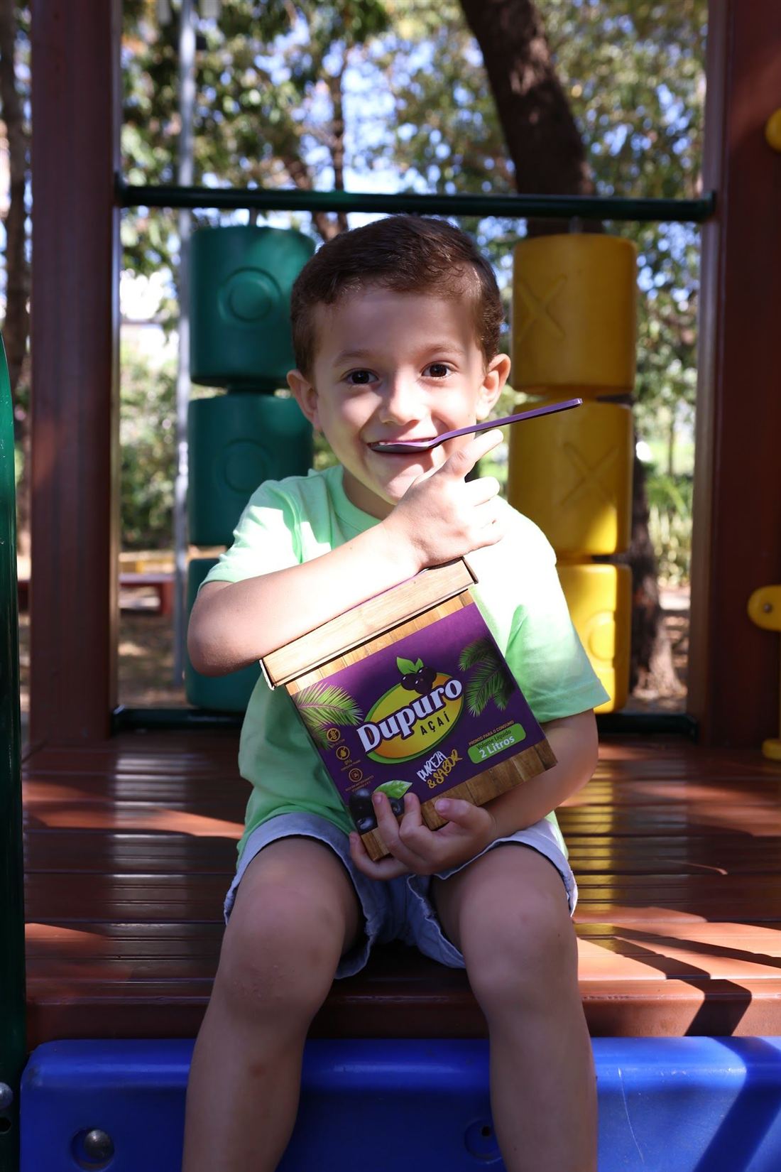 Menino sorrindo segurando uma caixa Dupuro